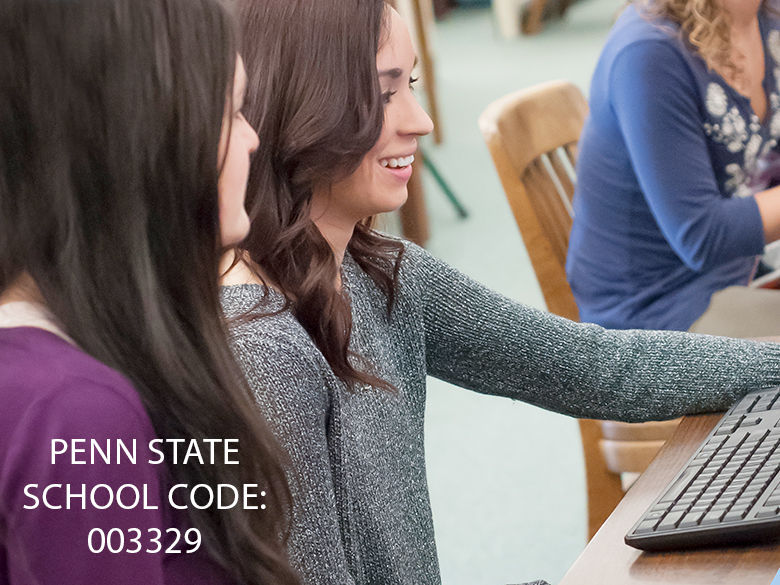 two students review Penn State Scranton financial aid on a computer in the library