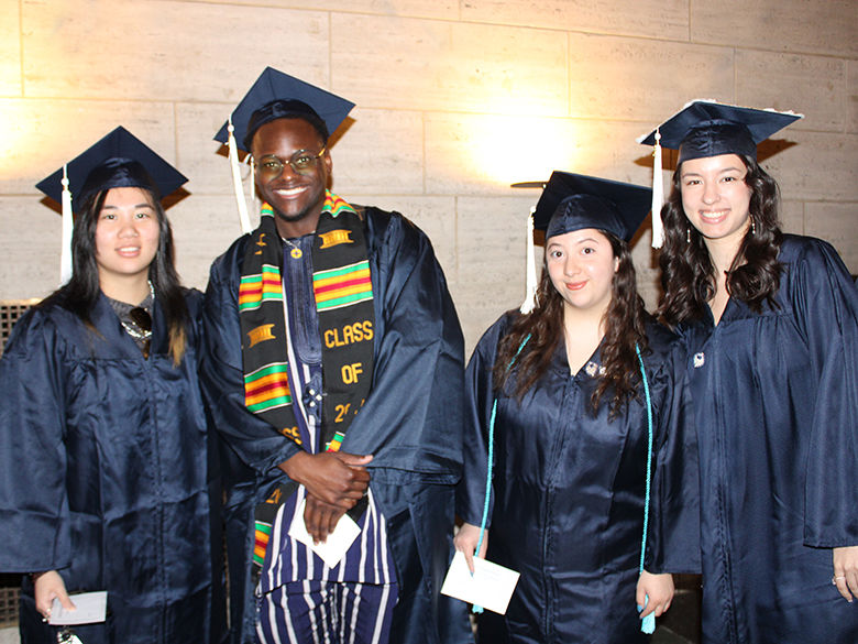 four smiling graduates