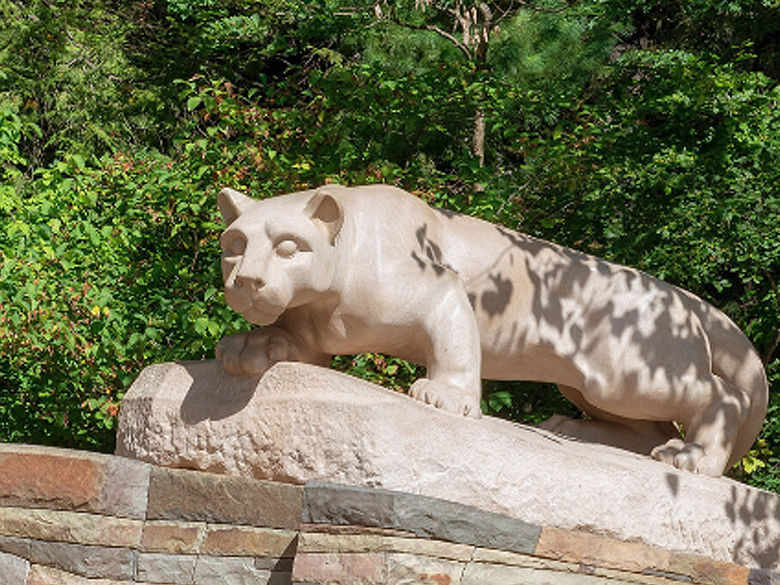 lion shrine statue surrounded by green leaves an trees