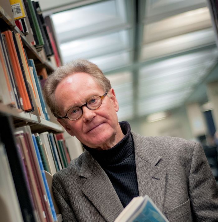 Dr. Phil Mosley in library holding book