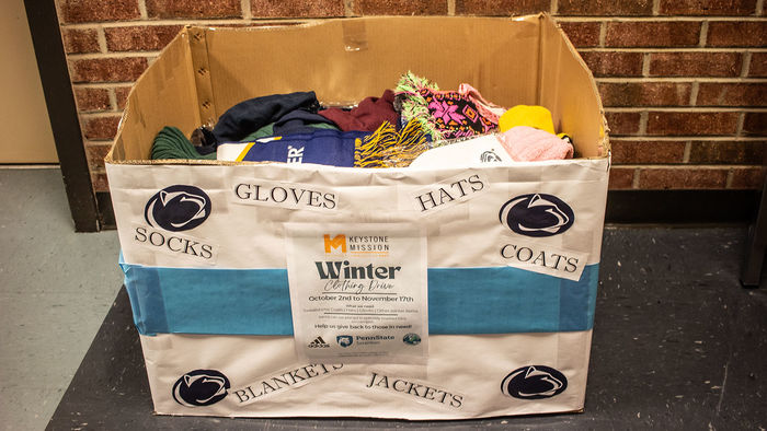 large cardboard box full of hats and scarves