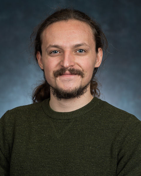 A headshot of Jasper Sachsenmeier wearing a black shirt.