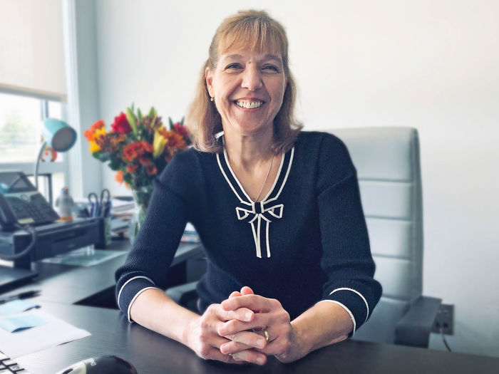 Jo Ann Durdan smiling, seated at her desk