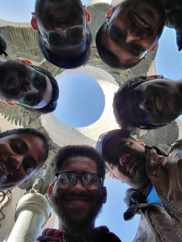 A group of students looking down at a camera in a circle