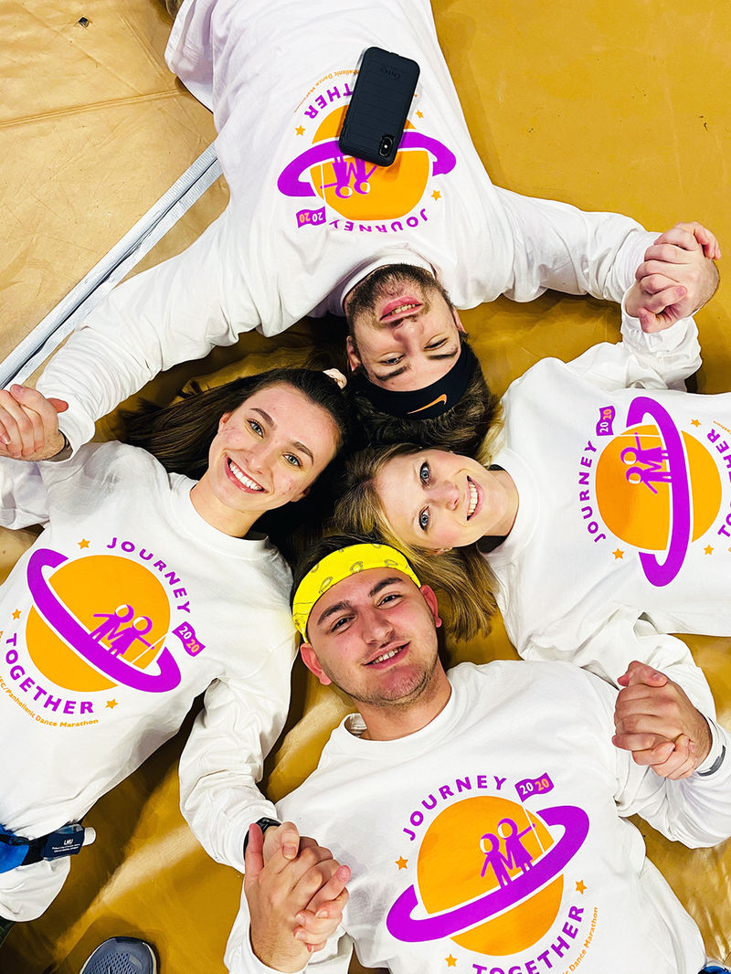 The dancers lying on the floor in a circle holding hands