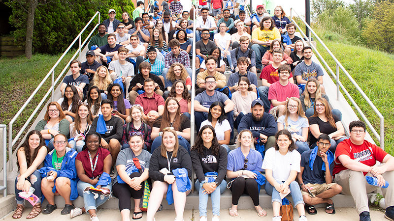 Large group of students sitting on steps.