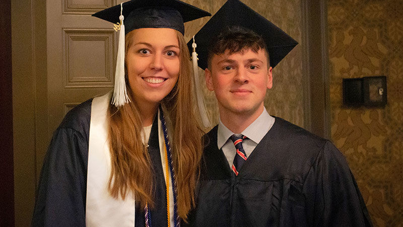 two smiling graduates