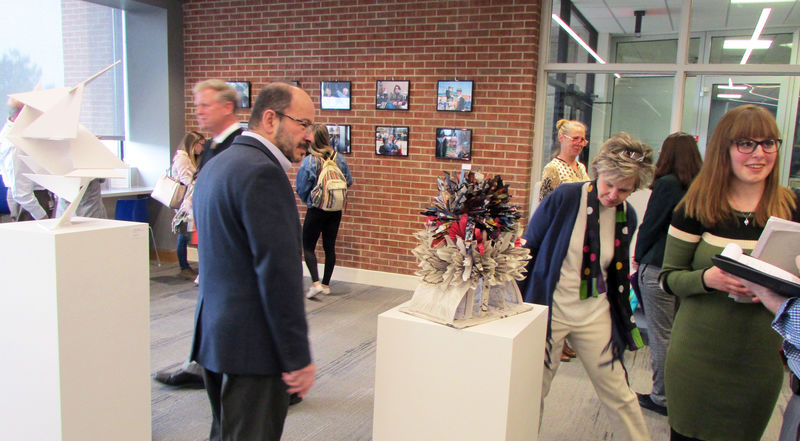 campus chancellor takes a closer look at one of the sculptures