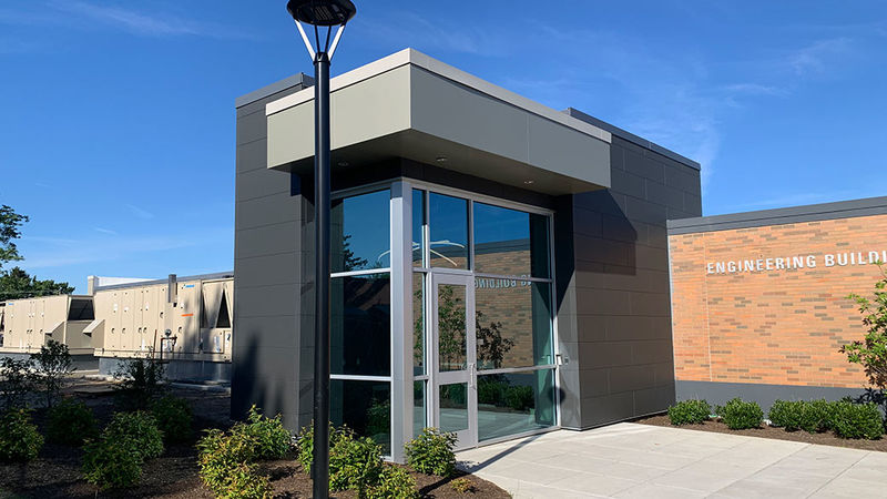 entrance through large glass foyer into one story brick building