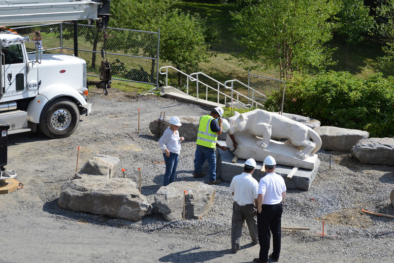 crews place lion at new site