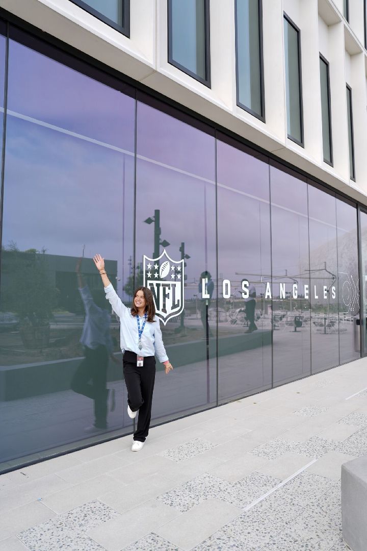 A student poses next to an NFL Los Angeles sign