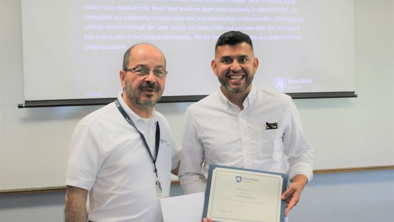 Chancellor Marwan Wafa, left, presents the Chancellor's Service Award certificate to Carlos Salazar Paz.