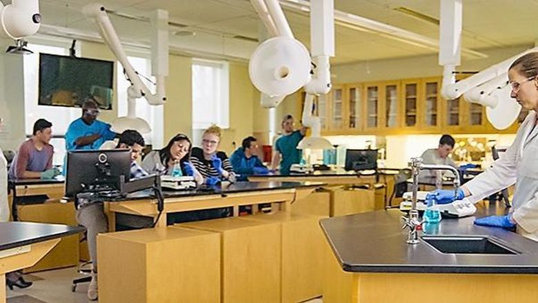 students in chemistry lab with instructor working in a group