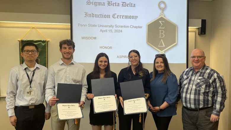 new inductees pose for a photo with faculty and honor society members