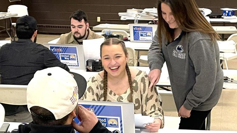 professor angela bassani assists a student during a volunteer session at VITA