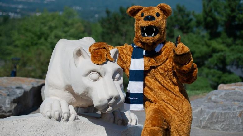 nittany lion mascot posing for photo at nittany lion shrine, pointing toward camera