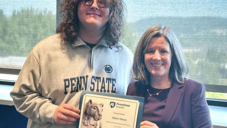 Student adam horan receiving certificate from chancellor liz wright