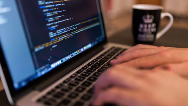 Close-up photo of hands typing on a laptop computer