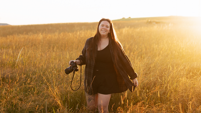 Photo of Maggie Kraser in a wheat field at sunset