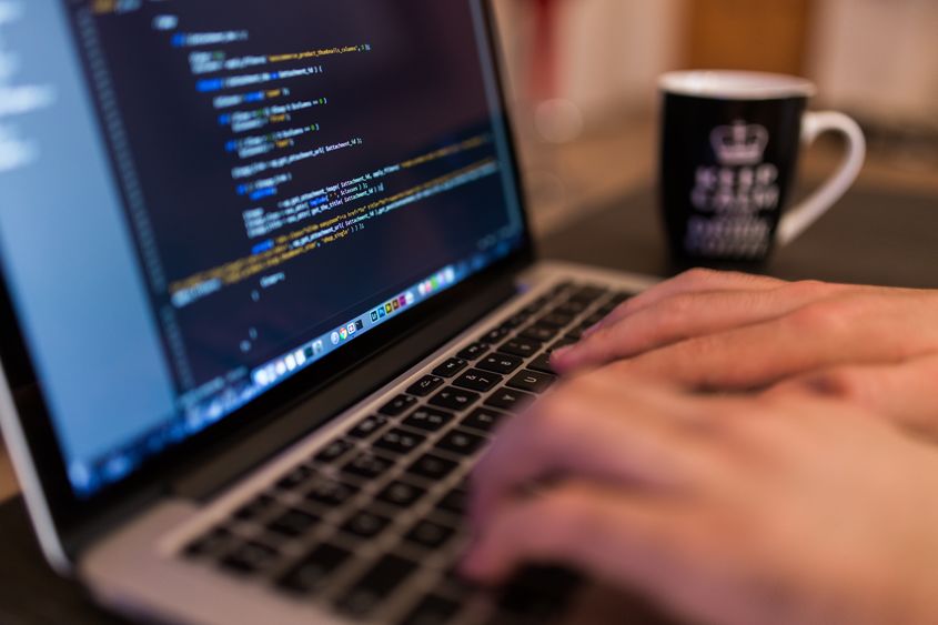 Close-up photo of hands typing on a laptop computer