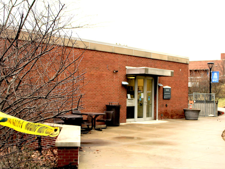 construction tape cordons off campus library entrance at start of renovation project