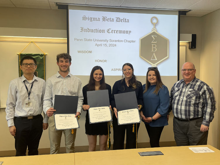 new inductees pose for a photo with faculty and honor society members